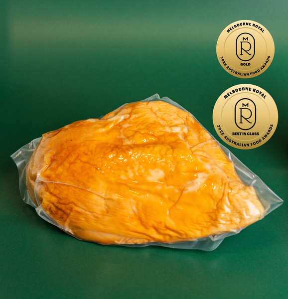 The Lucky Pig’s award-winning free-range smoked chicken breast, golden brown and vacuum-packed, with Melbourne Royal 2025 medal badge.