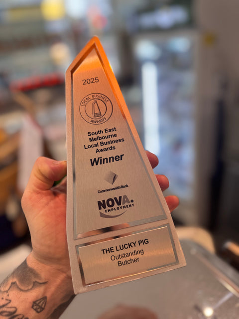 Award for Outstanding Butcher held by a person with blurred background