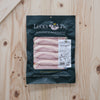 The Lucky Pig short cut bacon in a 200 g retail pouch on a wooden board